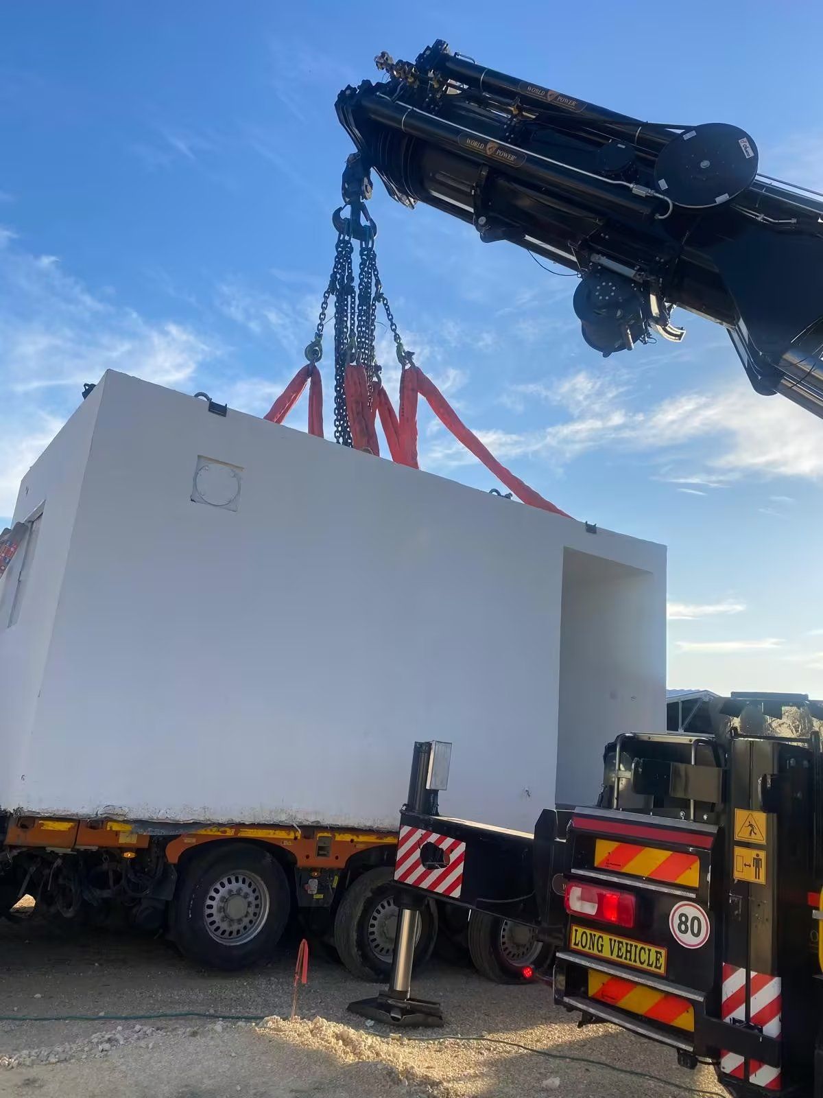 A reinforced concrete protected space being lowered into place by crane